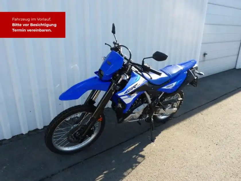 Das Bild zeigt eine blaue Yamaha WR125 von der Seite. Es enthält markante Texteinblendungen mit der Aufforderung, einen Termin zu vereinbaren.