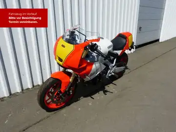 Das Bild zeigt eine YAMAHA XSR 900 von der Seite in orange und weiß, mit markanten Texteinblendungen.
