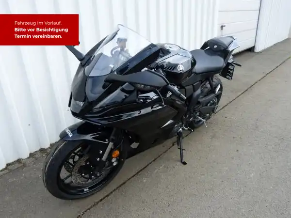 Das Bild zeigt eine schwarze YAMAHA YZF-R7 von der Seite. Es gibt Texteinblendungen in rot, die Informationen über das Fahrzeug enthalten.